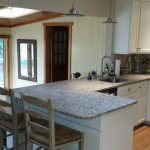 A kitchen with white cabinets and granite countertops