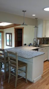 A kitchen with white cabinets and granite countertops