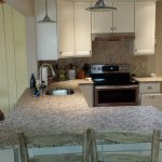 A kitchen with white cabinets and granite countertops