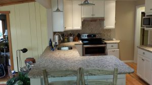 A kitchen with white cabinets and granite countertops