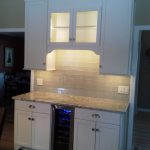 A white kitchen cabinet with new lights installed underneath
