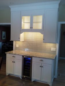A white kitchen cabinet with new lights installed underneath