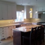 A clean, modern kitchen with white cabinets